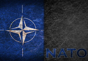 Image showing Old rusty metal sign with a NATO flag