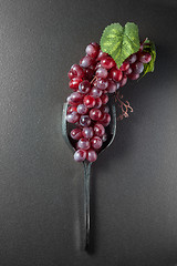 Image showing Wine glass made of forks and grape on black