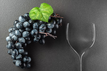 Image showing Wine glass made of forks and grape on black