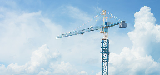 Image showing Tall Construction Crane Stands Against a Cloudy Sky