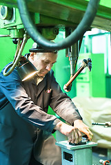 Image showing Elderly worker watches on milling machine work