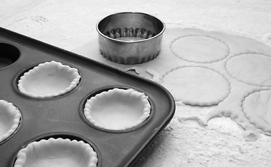 Image showing Pastry circles cut and lining a metal bun tin