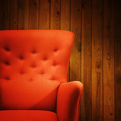 Image showing Classic red armchair near a wooden wall