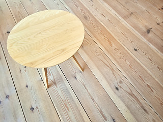 Image showing Simple round table on wooden floor