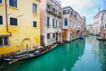 Image showing Gondolas parked next to houses in water canal
