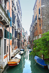 Image showing Gondolas moored in water canal next to buildings