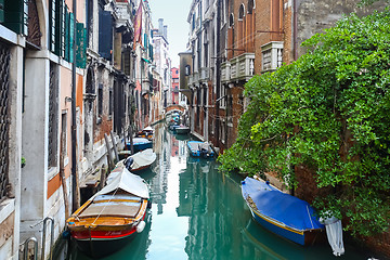 Image showing Gondolas parked in front of buildings in water canal