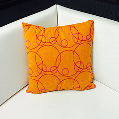 Image showing Orange cushion decorating a white sofa