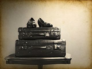 Image showing Vintage suitcases and shoes on a table