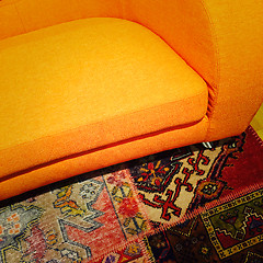 Image showing Bright orange sofa on colorful carpet