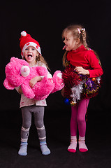 Image showing Two girls in Christmas clothes grimace