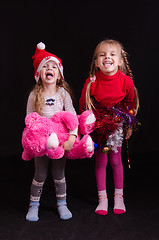 Image showing Two girls grimace and show language in Christmas clothes