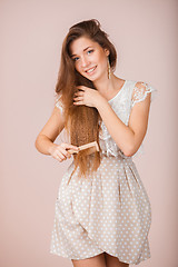 Image showing Smiling Girl combs her hair