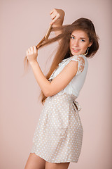 Image showing Smiling Girl combs her hair