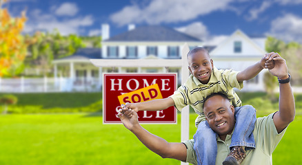 Image showing Father and Son In Front of Real Estate Sign and Home