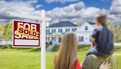 Image showing Family Facing Sold For Sale Real Estate Sign and House