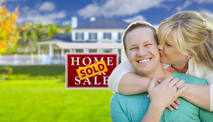 Image showing Happy Couple In Front Sold Real Estate Sign and House