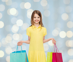 Image showing smiling little girl in dress with shopping bags