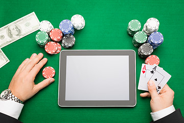 Image showing casino poker player with cards, tablet and chips