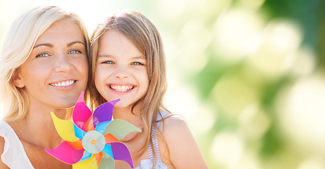 Image showing happy mother and little girl with pinwheel toy