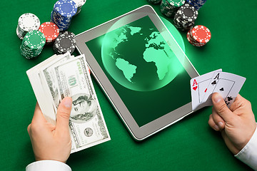 Image showing casino poker player with cards, tablet and chips