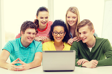 Image showing smiling students looking at laptop at school