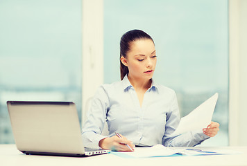 Image showing businesswoman with laptop and charts in office