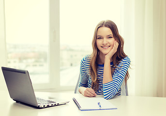 Image showing smiling teenage girl laptop computer and notebook