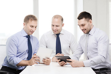 Image showing three smiling businessmen with tablet pc in office