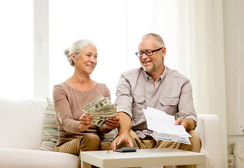 Image showing senior couple with money and calculator at home