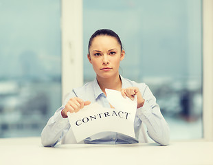 Image showing serious businesswoman tearing contract