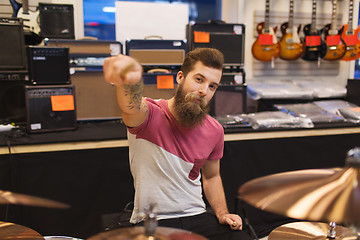 Image showing male musician playing cymbals at music store