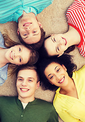 Image showing group of smiling people lying down on floor