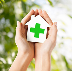 Image showing hands holding paper house with green cross