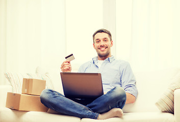 Image showing man with laptop, credit card and cardboard boxes
