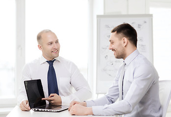 Image showing two smiling businessmen with laptop in office