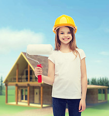 Image showing smiling little girl in helmet with paint roller