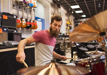 Image showing male musician playing cymbals at music store