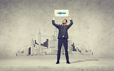 Image showing smiling businessman with arrow on white board