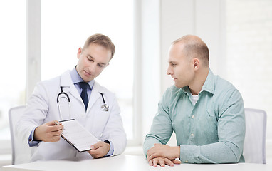 Image showing doctor with clipboard and patient in hospital