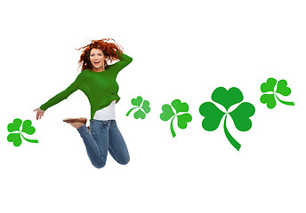 Image showing smiling teenage girl jumping in air with shamrock