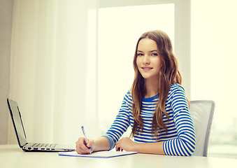 Image showing smiling teenage girl laptop computer and notebook