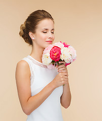 Image showing smiling woman in white dress with bouquet of roses