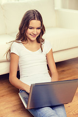 Image showing smiling teenage girl with laptop computer at home