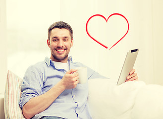 Image showing smiling man working with tablet pc at home