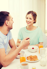 Image showing smiling couple having breakfast at home