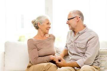 Image showing happy senior couple hugging on sofa at home