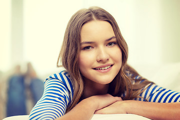 Image showing smiling teenage girl lying on sofa at home