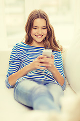 Image showing smiling teenage girl with smartphone at home