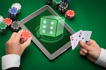 Image showing casino poker player with cards, tablet and chips